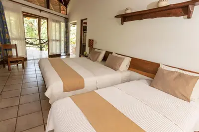 two beds sitting in a room with at Cabinas Las Olas in Playa Avellana