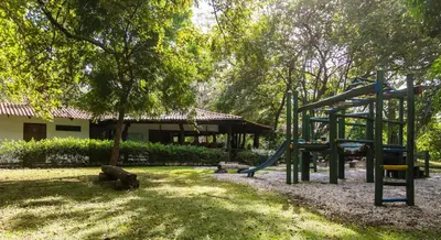 a playground with a slide in a park at Cabinas Las Olas in Playa Avellana