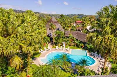an aerial view of a resort with a swimming pool and palm trees at Hotel Lavas Tacotal in Fortuna