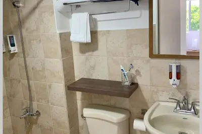 a bathroom with a toilet and a sink and a mirror at Costa Linda 1-19, walking distance from the beach in Jacó