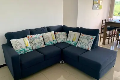 a blue couch with pillows on it in a living room at Costa Linda 1-19, walking distance from the beach in Jacó