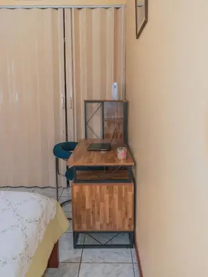 a desk with a laptop on it next to a bed at Linda casa de verano con amplias zonas verdes in San Isidro