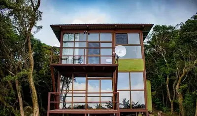a tree house with a large glass window at Sunset Vista Lodge,Monteverde,Costa Rica. in Monteverde Costa Rica