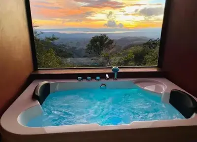 a bath tub with a window with a view at Sunset Vista Lodge,Monteverde,Costa Rica. in Monteverde Costa Rica
