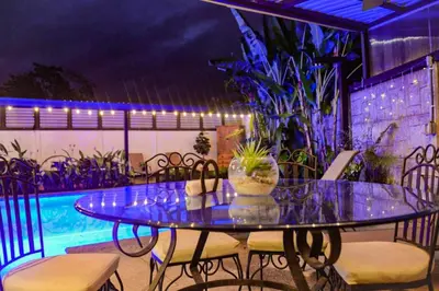 a glass table with chairs and a pool at Casa Kamagu in Fortuna