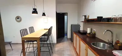 a kitchen with a table and chairs and a sink at Riverside Apartments - Walk to the Beach in Santa Teresa! Newly Renovated! in Santa Teresa Beach