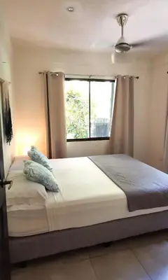 a bedroom with a large bed with a window at Riverside Apartments - Walk to the Beach in Santa Teresa! Newly Renovated! in Santa Teresa Beach
