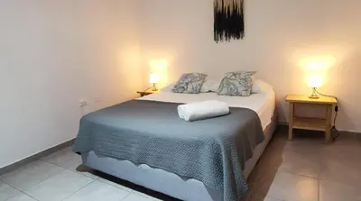 a bedroom with a bed and two lamps on two tables at Riverside Apartments - Walk to the Beach in Santa Teresa! Newly Renovated! in Santa Teresa Beach