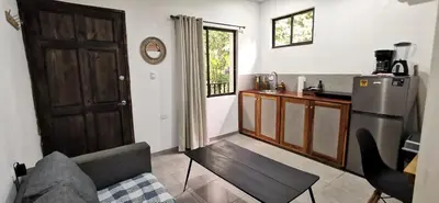 a kitchen with a couch and a refrigerator in a room at Riverside Apartments - Walk to the Beach in Santa Teresa! Newly Renovated! in Santa Teresa Beach
