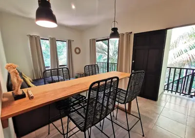 a dining room with a wooden table and chairs at Riverside Apartments - Walk to the Beach in Santa Teresa! Newly Renovated! in Santa Teresa Beach