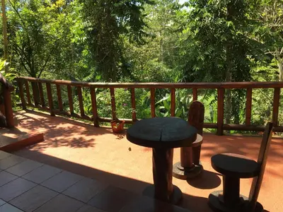 a patio with a table and chairs on a deck at Hotel Samsara in Uvita