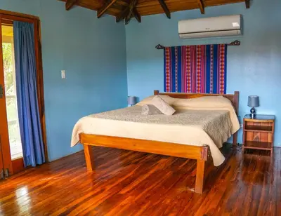 a bedroom with a bed with a wooden floor at Apartamento Boruca Tamarindo in Tamarindo