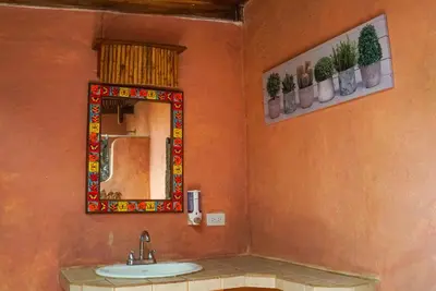 a bathroom with a sink and a mirror at Apartamento Boruca Tamarindo in Tamarindo