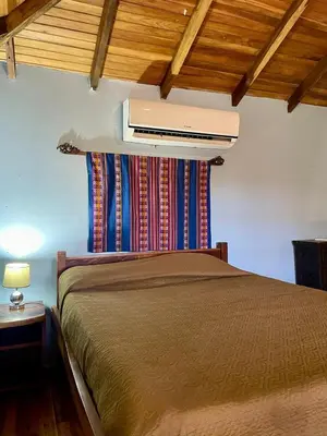 a bedroom with a bed with a air conditioner on the wall at Apartamento Boruca Tamarindo in Tamarindo