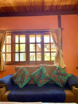 a couch with pillows on it in a room with windows at Apartamento Boruca Tamarindo in Tamarindo