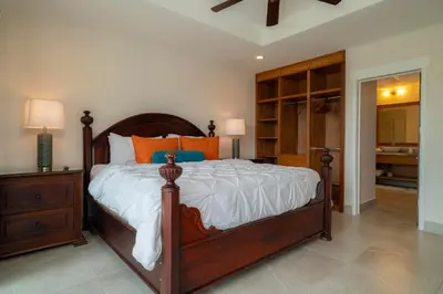 a bedroom with a large bed with white sheets and orange pillows at Casa Patron 6 bdrs pool in Los Suenos in Herradura