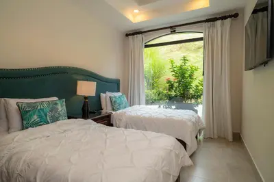 a bedroom with two beds and a window at Casa Patron 6 bdrs pool in Los Suenos in Herradura