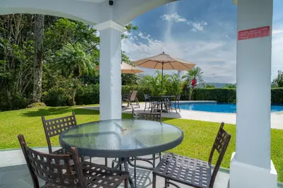 a patio with a table and chairs and a pool at Casa Patron 6 bdrs pool in Los Suenos in Herradura
