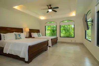 a bedroom with two beds and a ceiling fan at Casa Patron 6 bdrs pool in Los Suenos in Herradura
