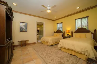 a bedroom with two beds and a ceiling fan at Casa Oasis 5 bdrs private pool in Los Suenos in Herradura