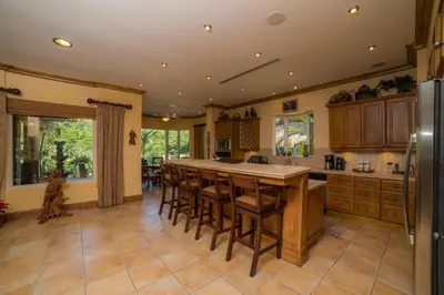 a large kitchen with a large island with bar stools at Casa Oasis 5 bdrs private pool in Los Suenos in Herradura