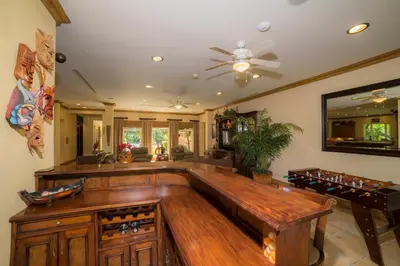 a large game room with a wooden bench and a table at Casa Oasis 5 bdrs private pool in Los Suenos in Herradura