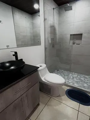 a bathroom with a toilet and a sink and a shower at Mevak Apartments Suites in Fortuna
