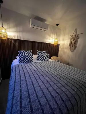 a bedroom with a blue bed with blue and white pillows at Mevak Apartments Suites in Fortuna