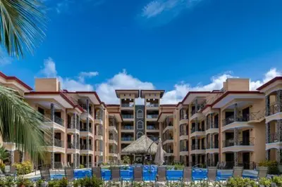 a view of a resort with a palm tree at Beautiful and Enchanting Beach Vacation in Jacó