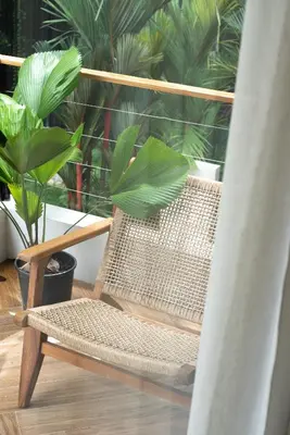 a rattan chair sitting on a balcony with plants at Nala Luxury Living - Santa Teresa - Costa Rica in Santa Teresa Beach