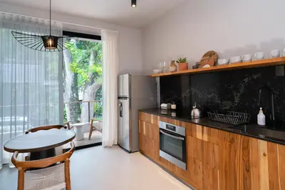 a kitchen with a table and a stainless steel refrigerator at Nala Luxury Living - Santa Teresa - Costa Rica in Santa Teresa Beach
