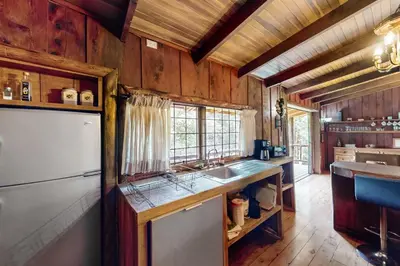 a kitchen with wooden walls and a refrigerator and a sink at Hacienda Milinda in Birrí