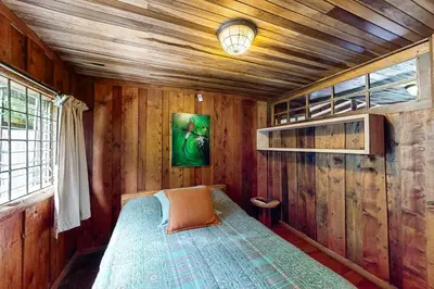 a bedroom with a bed in a wooden room at Hacienda Milinda in Birrí