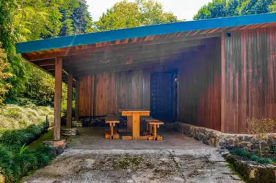 a wooden pavilion with a wooden table and benches at Hacienda Milinda in Birrí