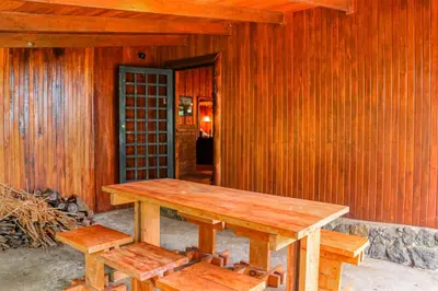 a wooden picnic table and benches in front of a building at Hacienda Milinda in Birrí