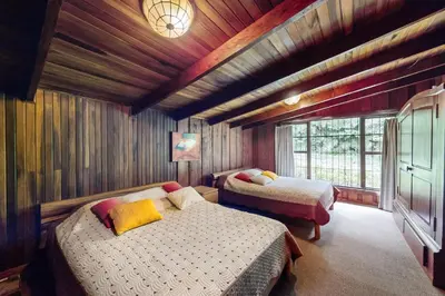 a bedroom with two beds in a room with wooden walls at Hacienda Milinda in Birrí