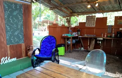 a room with two chairs and a wooden table at Fully Furnished FAMILY JUNGLE TENT, Latino Glamping Paquera in Paquera
