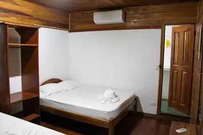 a small room with a bed and a mirror at Hotel La Cascada in Puntarenas