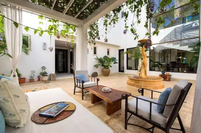 a patio with a table and chairs and a fountain at Exquisite Hilltop Villa with Luxurious Modern Design, Sweeping Ocean Views & Sparkling Infinity Pool in Playa Flamingo