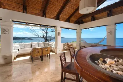 a living room with a hot tub and a view of the ocean at Exquisite Hilltop Villa with Luxurious Modern Design, Sweeping Ocean Views & Sparkling Infinity Pool in Playa Flamingo