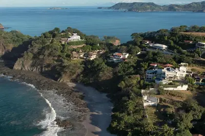 an aerial view of a beach with houses and the ocean at Exquisite Hilltop Villa with Luxurious Modern Design, Sweeping Ocean Views & Sparkling Infinity Pool in Playa Flamingo