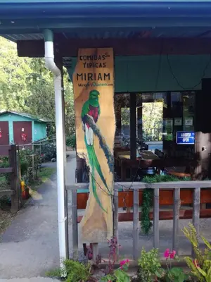 a sign for a restaurant with a parrot on it at Cabañas San gerardo in San Gerardo de Dota