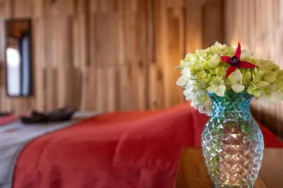 a glass vase filled with flowers on a table at Paraíso Quetzal Lodge in Tres de Junio
