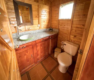 a small bathroom with a toilet and a sink at Paraíso Quetzal Lodge in Tres de Junio