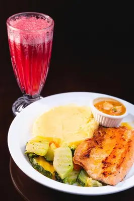 a plate of food with meat and vegetables and a drink at Paraíso Quetzal Lodge in Tres de Junio