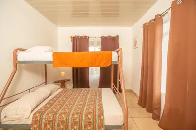 a small room with two bunk beds and a window at Cozy coworking Casa Alma near Lake Arenal, 2 bedroom 1 office, fiber optic, pet friendly in Nuevo Arenal