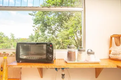 a microwave sitting on a counter next to a window at Cozy coworking Casa Alma near Lake Arenal, 2 bedroom 1 office, fiber optic, pet friendly in Nuevo Arenal