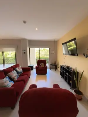 a living room with two red couches and a flat screen tv at Amaluc zac in Jacó