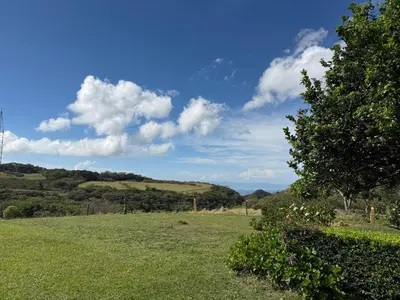 a field of grass with a blue sky and clouds at Campo Azul #2 - Monteverde in Monteverde Costa Rica