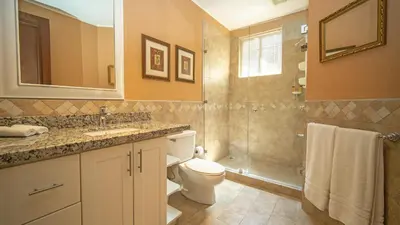 a bathroom with a toilet and a sink and a shower at Terrace 2BR Condo - Bougainvillea - Reserva Conchal Golf Resort in Playa Conchal